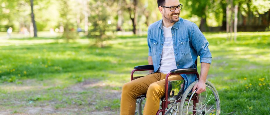 smiling man in wheelchair outdoors